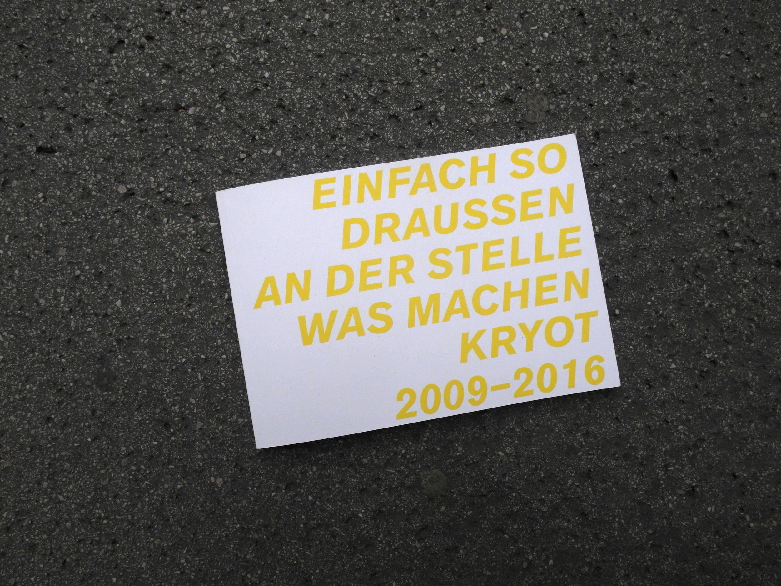 Closed book lying on the street. Title in yellow letters across the entire cover: Einfach so draussen an der Stelle was machen Kryot 2009-16