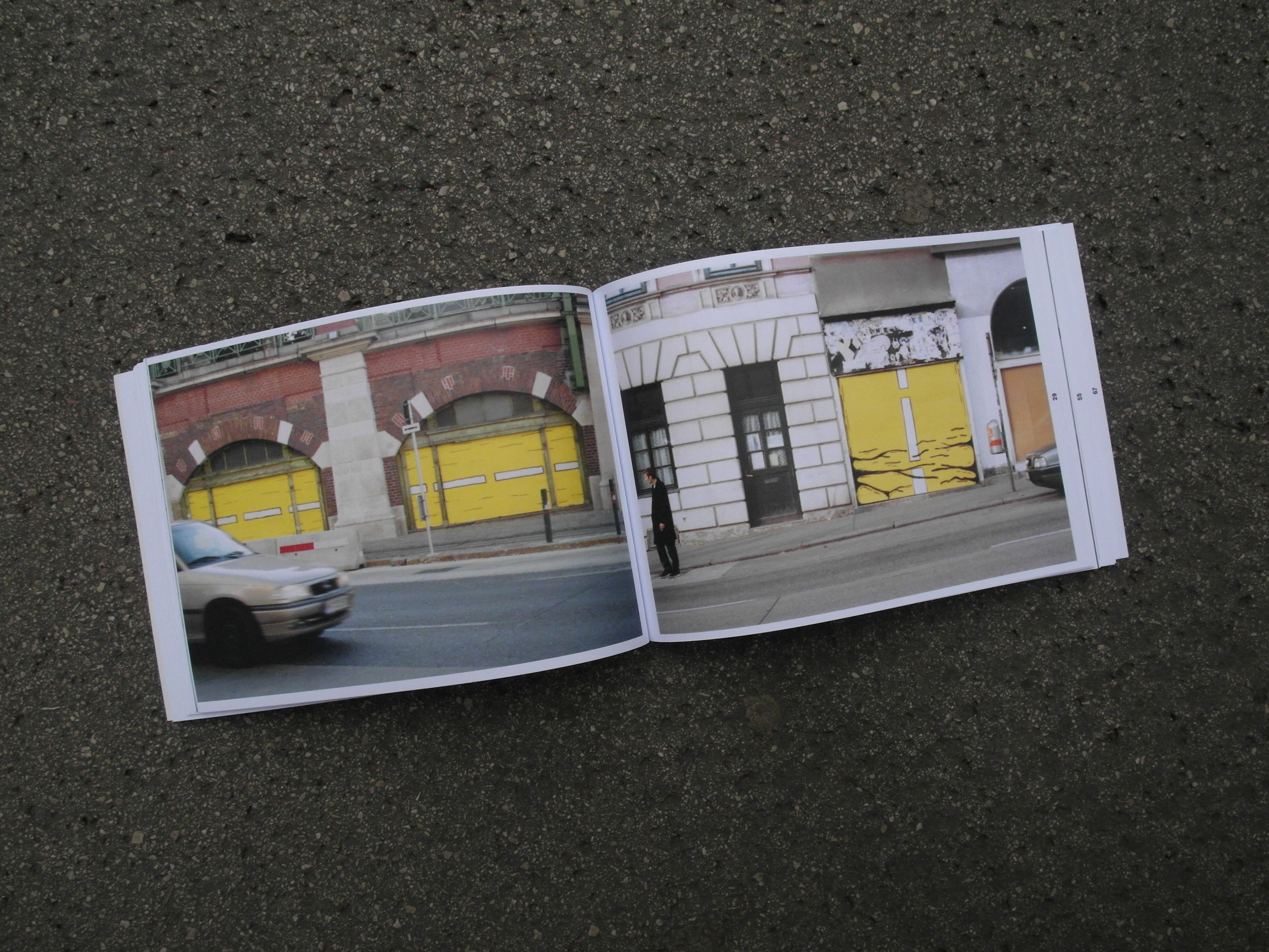 Open book lying on the street. 2 photos of old abandoned stores with shutters. Both painted with yellow/black motifs.